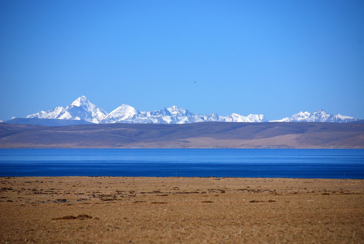 05 Lake Manasarovar And Sangthang and Peaks Of Indian Himalaya From First View Of Mount Kailash The Indian Himalaya stands above the blue waters of Lake Manasarovar seen from the crest of the small hill that has the first view of Mount Kailash. The tallest peak on the left is Sangthang (6480m) situated on Indo-Tibet border.